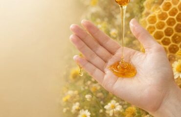 honey-skincare-benefits-golden-glow Close-up of honey skincare benefits with golden raw honey dripping on glowing skin against a natural honeycomb background